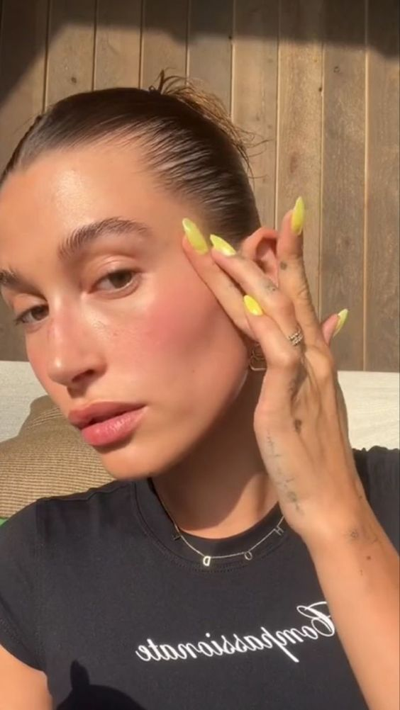 A selfie of Hailey bieber rocking the buttercup nails 