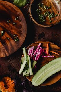 Cucumber, Carrots and Beets arranged on a wooden cutting board