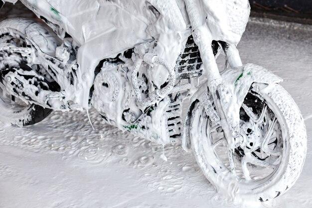 Premium Photo | Motorcycle in white foam at a car wash