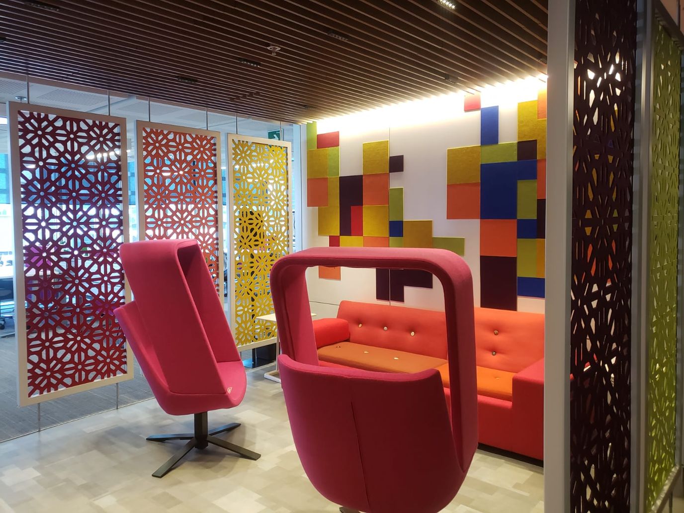 파펠 피카도에 영감을 받아 디자인한 패널, 주황색 소파와 빨간색 의자가 보이는 멕시코시티 오피스의 모습.