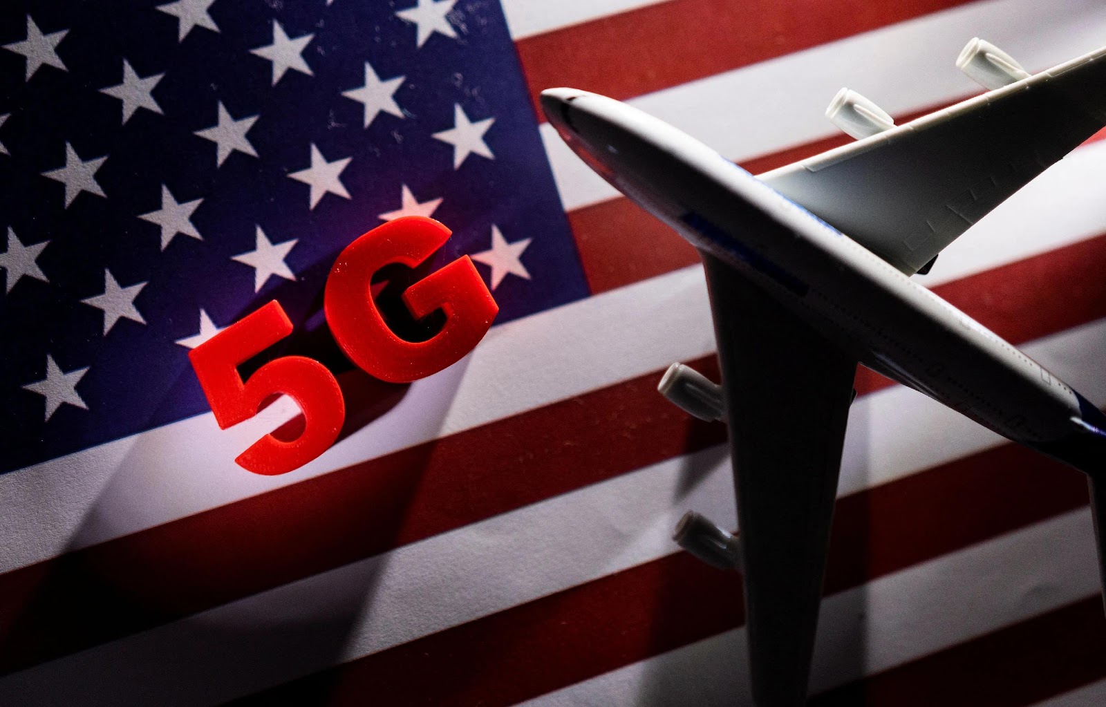 5G words and an airplane toy are placed on a printed U.S. flag in this illustration taken January 18, 2022. REUTERS/Dado Ruvic/Illustration