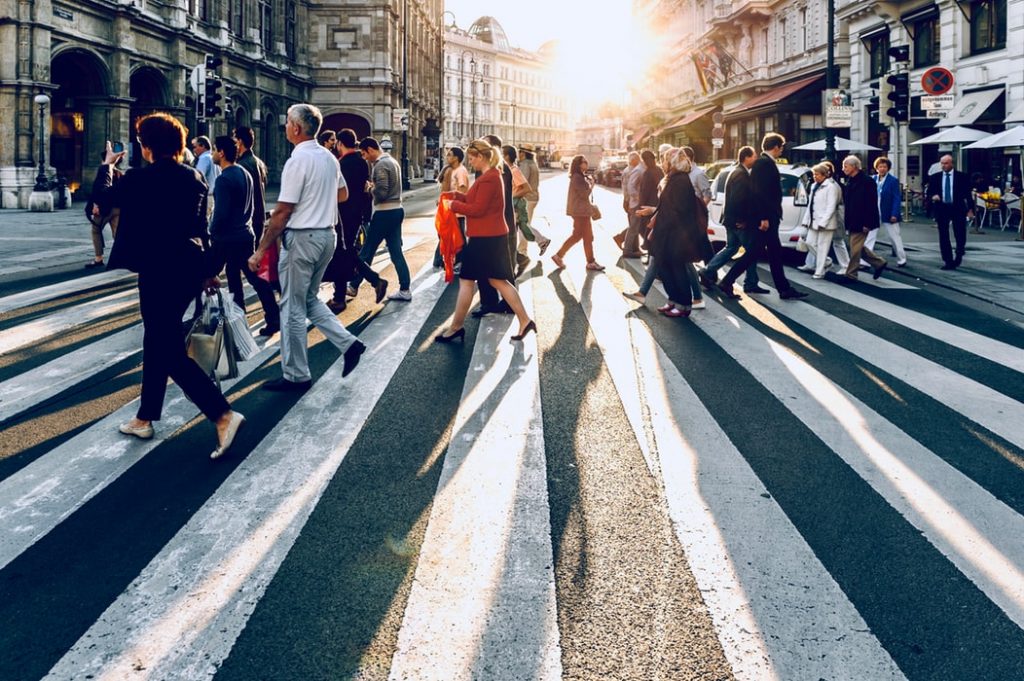 Grande avenida com muitas pessoas em circulao sobre faixa de pedestre