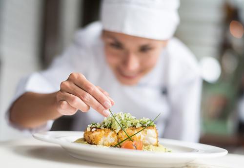 A chef eating a plate of food  Description automatically generated with medium confidence