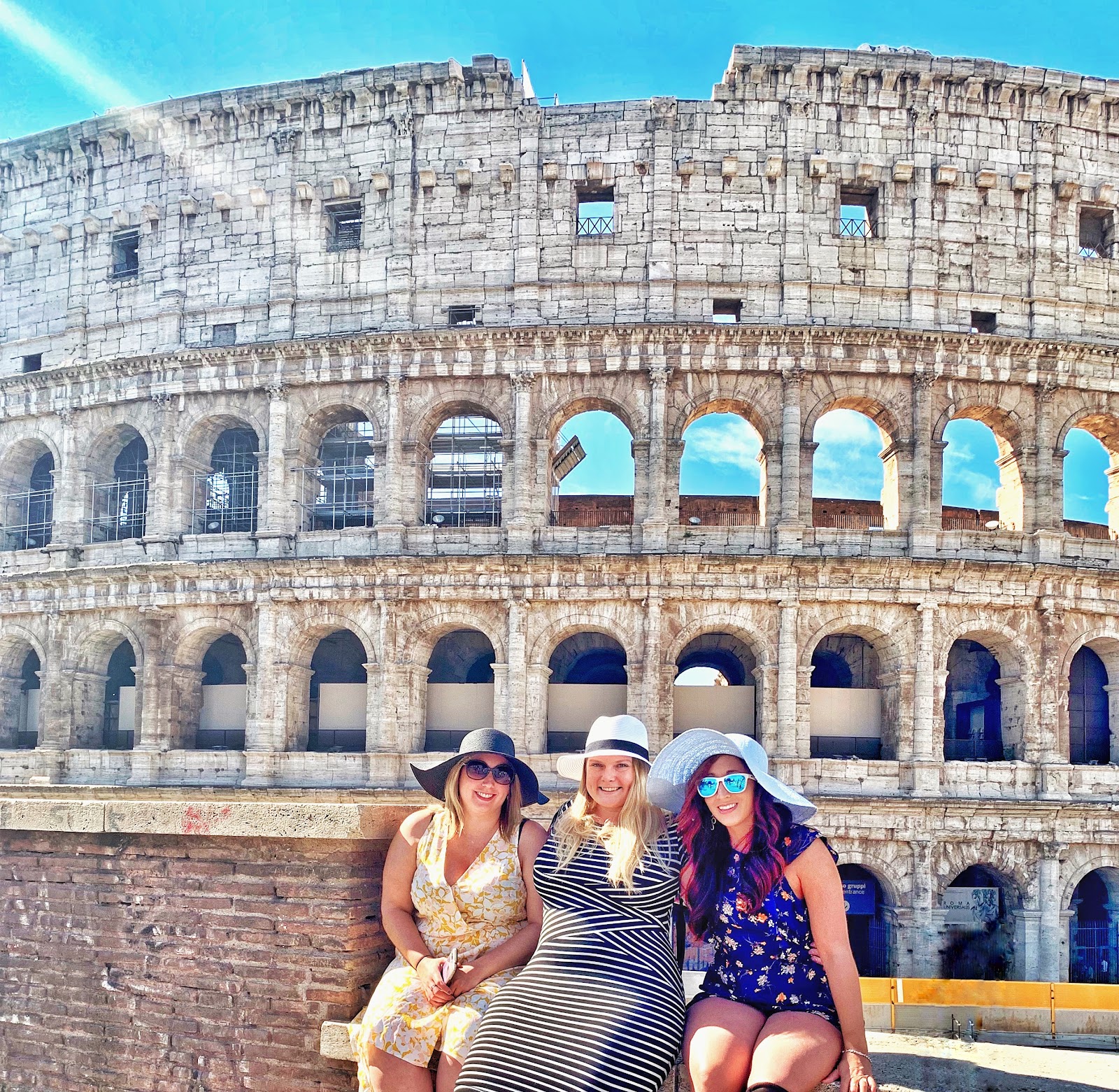 3 women posing in front of the Colosseum in Rome, Italy