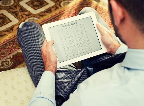 Playing on Sudoku games with digital tablet Playing on Sudoku games with digital tablet games online sudoku stock pictures, royalty-free photos & images