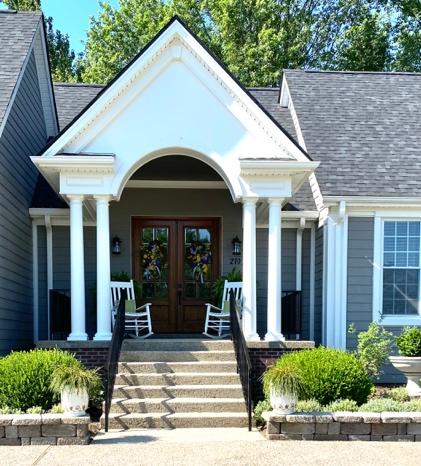 A house with bushes in front of a building

Description automatically generated