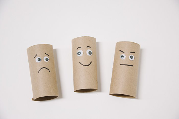 three toilet paper rolls with faces drawn on in marker and googly eyes - one is sad, one is happy, one is mad