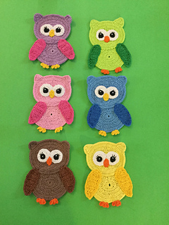 six owl appliques in different colors on green background