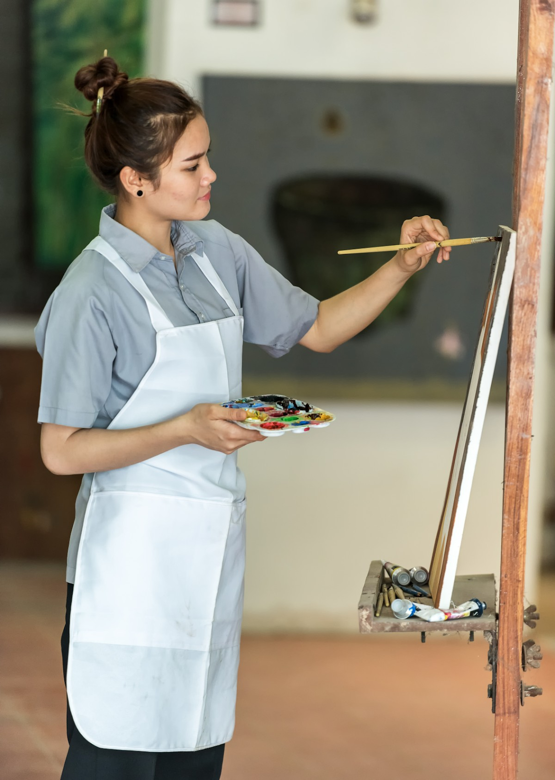 woman painitng on standing canvas thinking tomorrow will be better