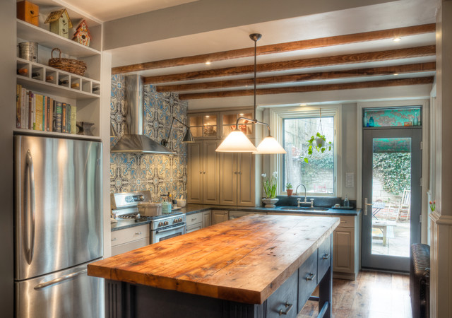 The large reclaimed butcher block countertop island is the main attraction in this eclectic farmhouse kitchen.