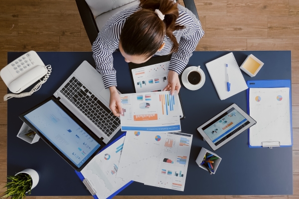 top-view-businesswoman-sitting-desk-table-checking-financial-accounting-documents