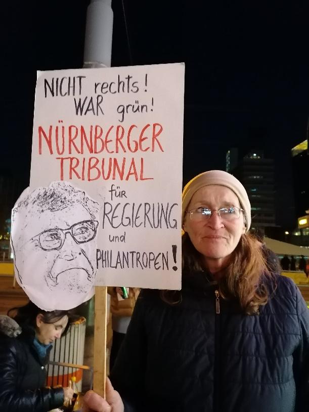 A person holding a sign

Description automatically generated