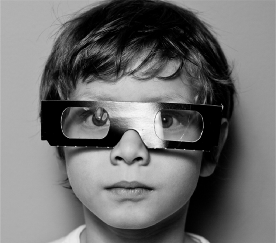 A boy wearing paper glasses