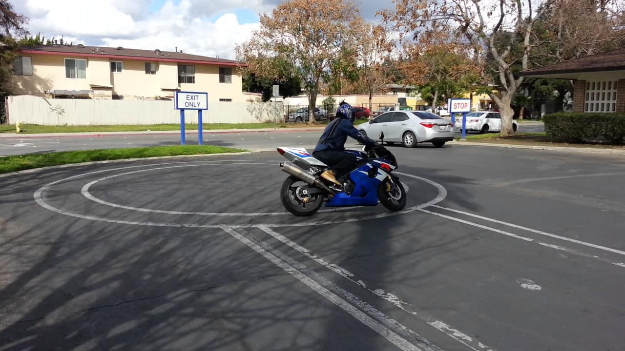 Motorcyclist riding out of parking lot onto open road adventure