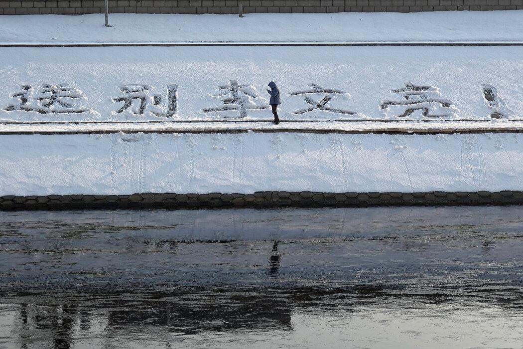 2月,北京一处河岸雪地上悼念李文亮的文字。李文亮曾对新冠病毒的严峻性发出警告,但被当局噤声,他死于Covid-19。