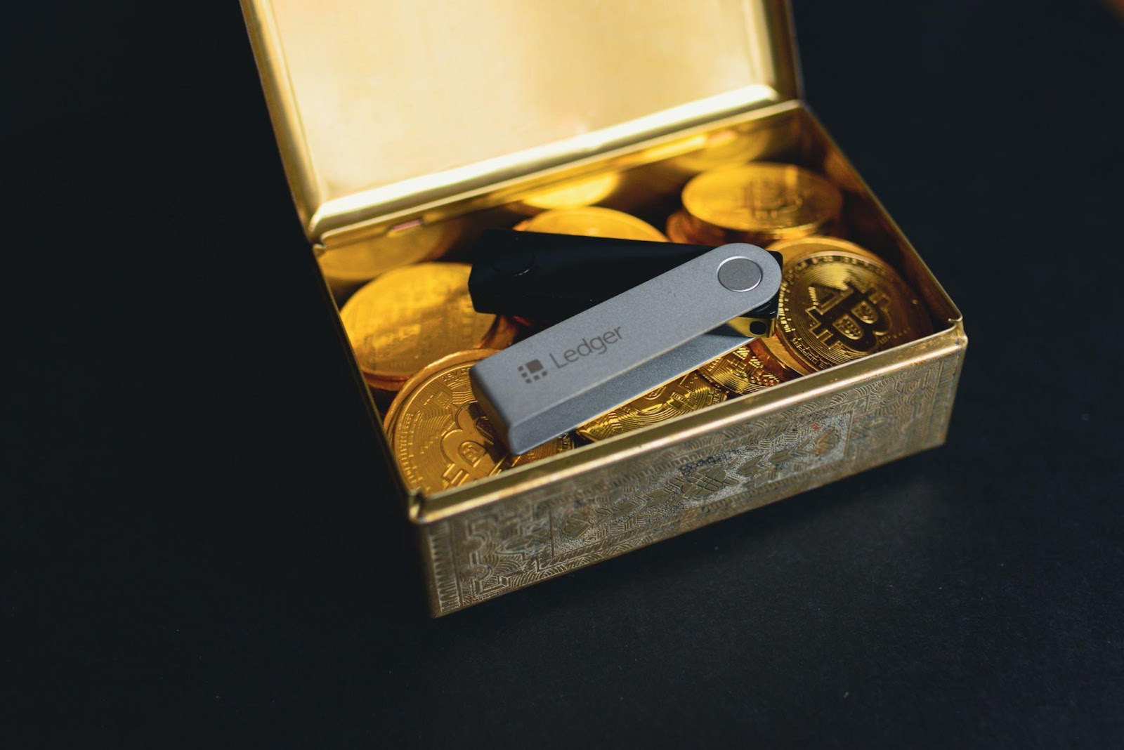 A USB drive lies on a box full of Bitcoin, representing scams that ThriveDX can educate employees on