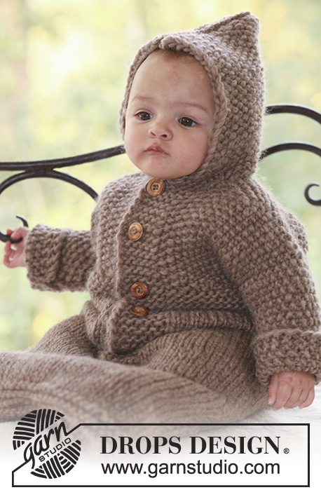 baby sitting up in a tan textured bunting bag with hood