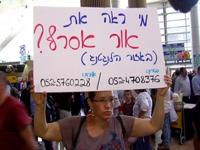 Orit Assraf sosteniendo un cartel en el Aeropuerto Ben Gurion