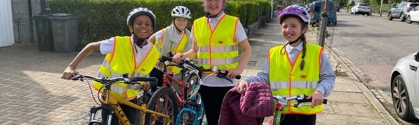 A group of people wearing safety vests and standing next to bicycles

Description automatically generated with low confidence