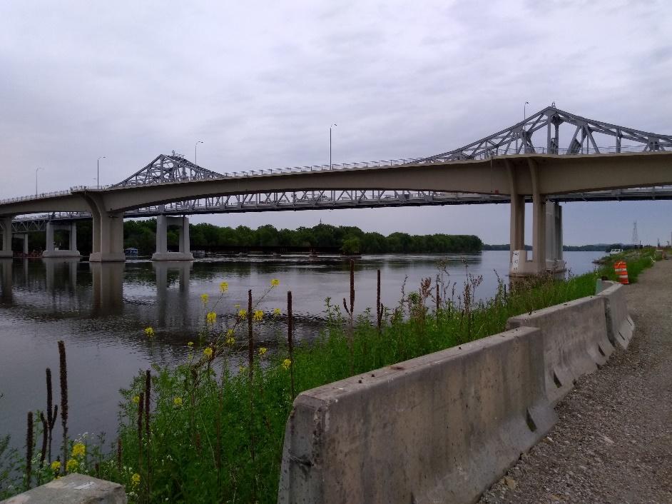 A train crossing a bridge over a body of water

Description automatically generated