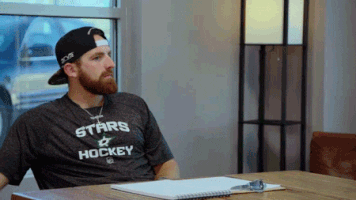 animated gif of a bearded man wearing his ball-cap backwards. He throws a pencil across the desk, covers his face with his hands and puts his head down on the desk dramatically.
