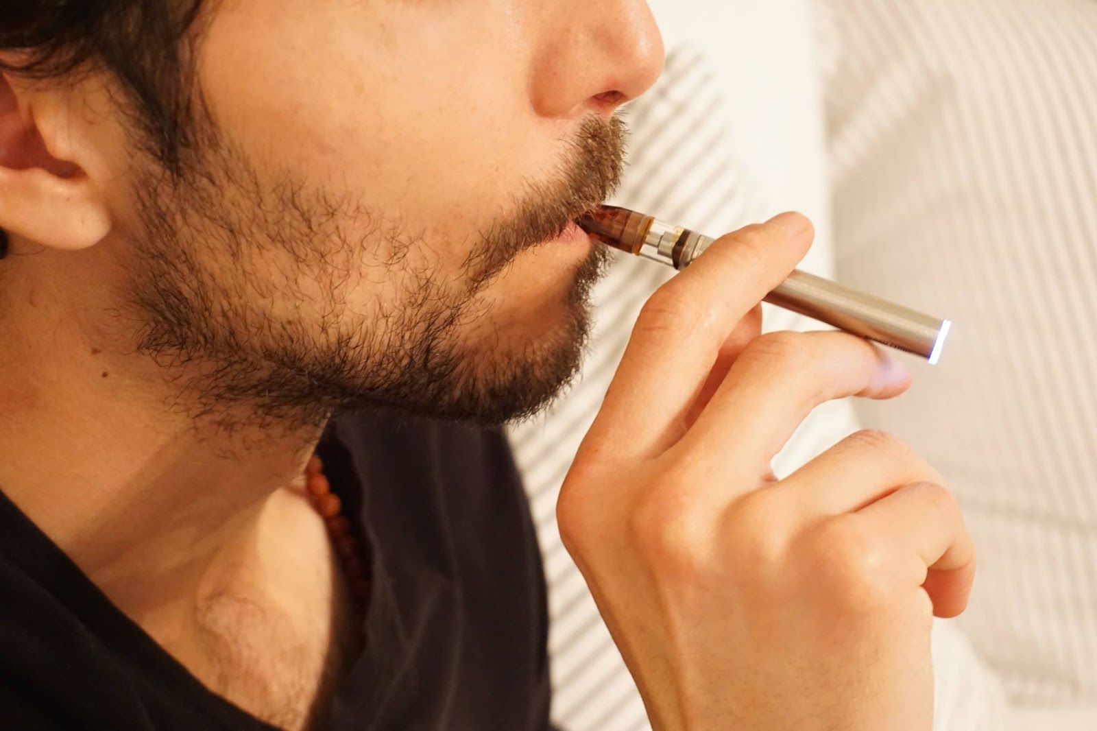 A man inhaling on an e-cigarette style vape