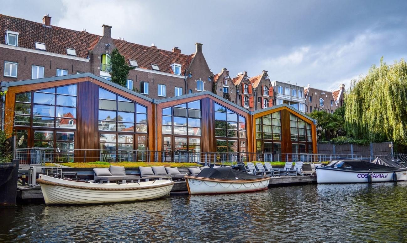 Barcas sobre el canal frente a un moderno edificio de cristal