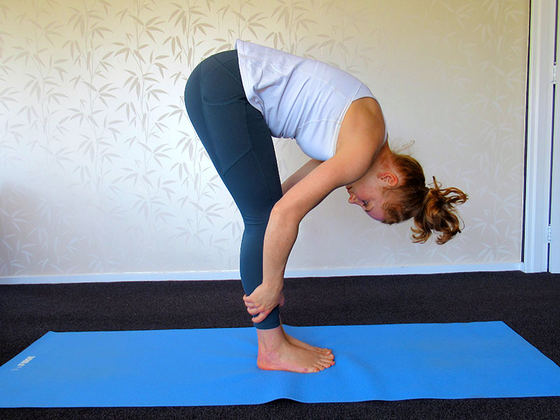 Standing forward bend yoga pose to reduce stress