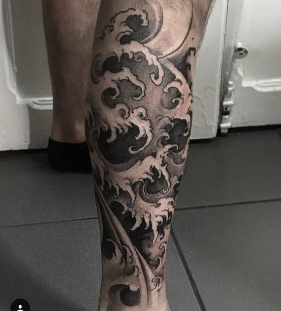 Full picture of a guy rocking the wave tattoo on his leg