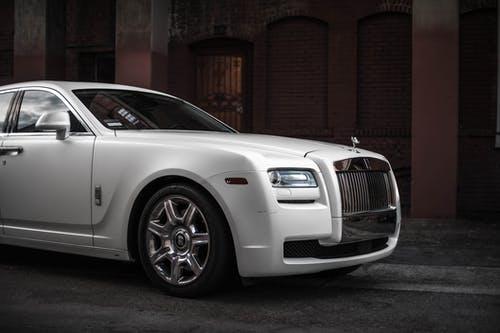 Photo of White Rolls-Royce Ghost Parked Near Brown Building