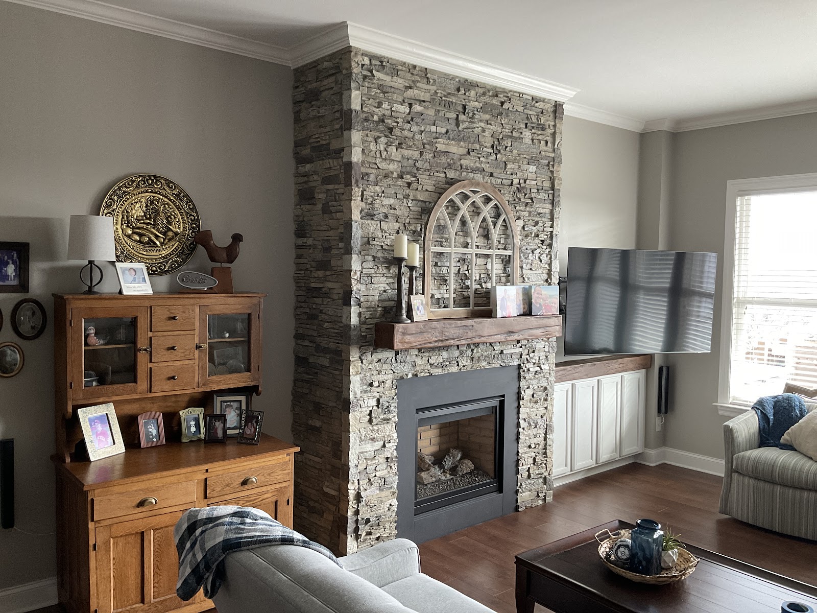 Faux Wood Mantel and Faux Stone Wall Panel In Fireplace Design.