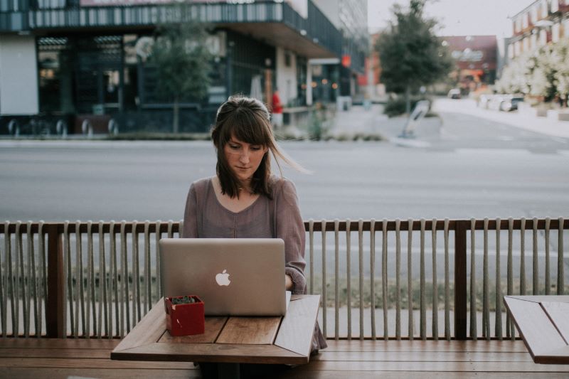 An image of a woman at a coffee shop going through remote employee training.