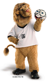 Goleo the lion standing wearing soccer jersey holding a soccer ball