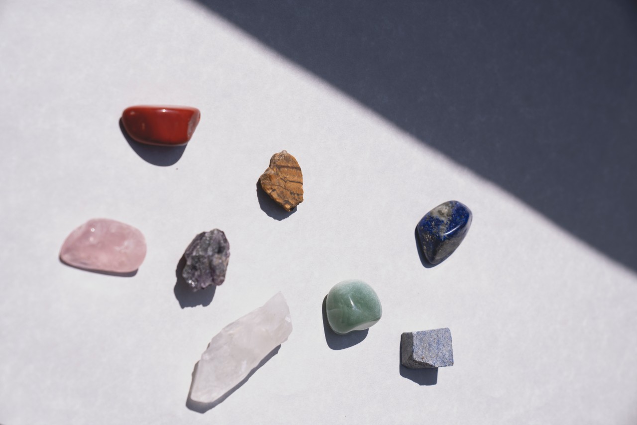 Eight different colored and shaped stones. Some of the stones are smooth and others are rough.