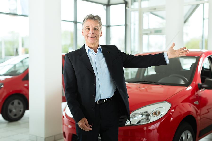Mature man showing a car in a dealership