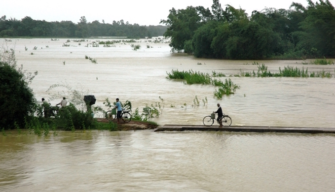 People fleeing the Brahmaputra floods on foot and by cycle [image by Kshitiz Anand]