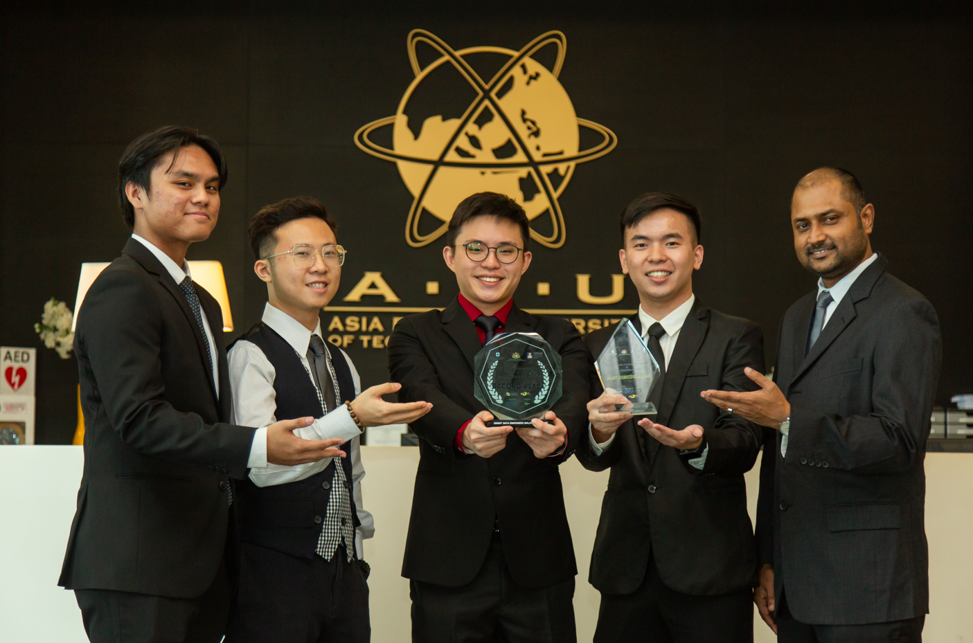 A group of men in suits holding a trophy

Description automatically generated