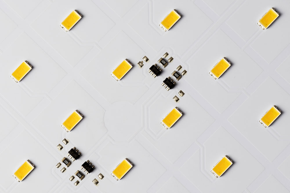 Top view of white aluminum electronic circuits with SMD LEDs and microchips.