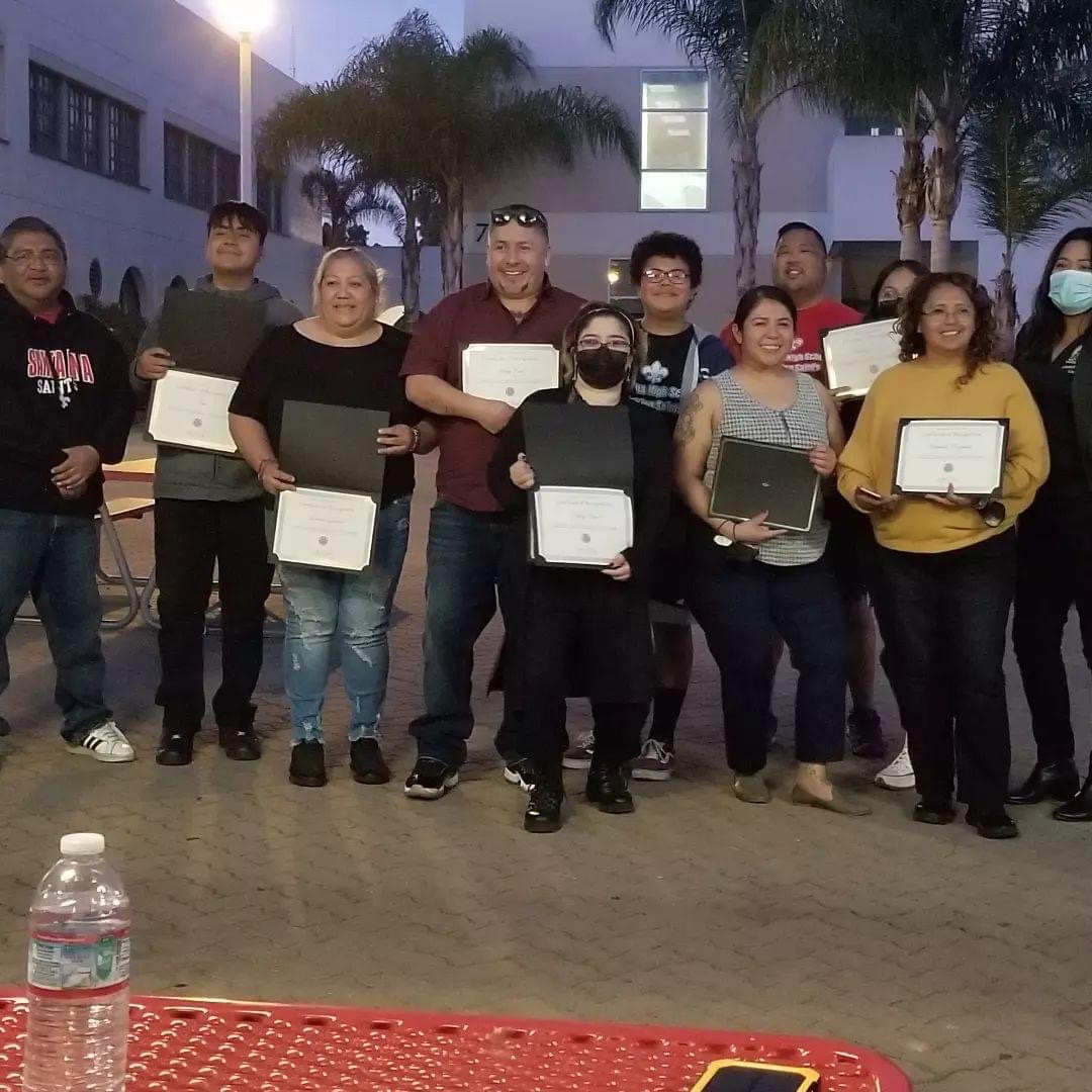 A group of students pose with certificates at the Booster Club Friendsgiving