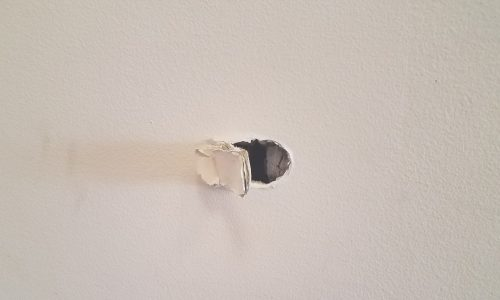 A hole in a white wall.