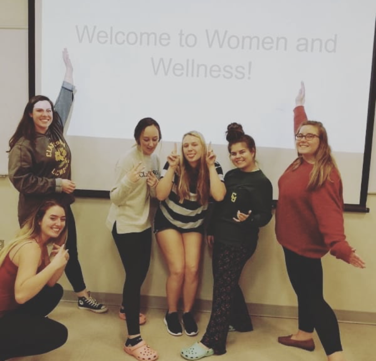 Women and Wellness members posing in front of their presentation 