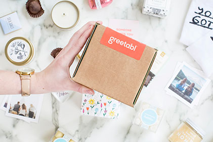 Image of person holding a Greetabl shipping box and gift options.