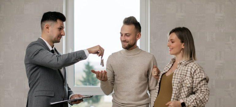 real estate agent handing the house keys to the new owners