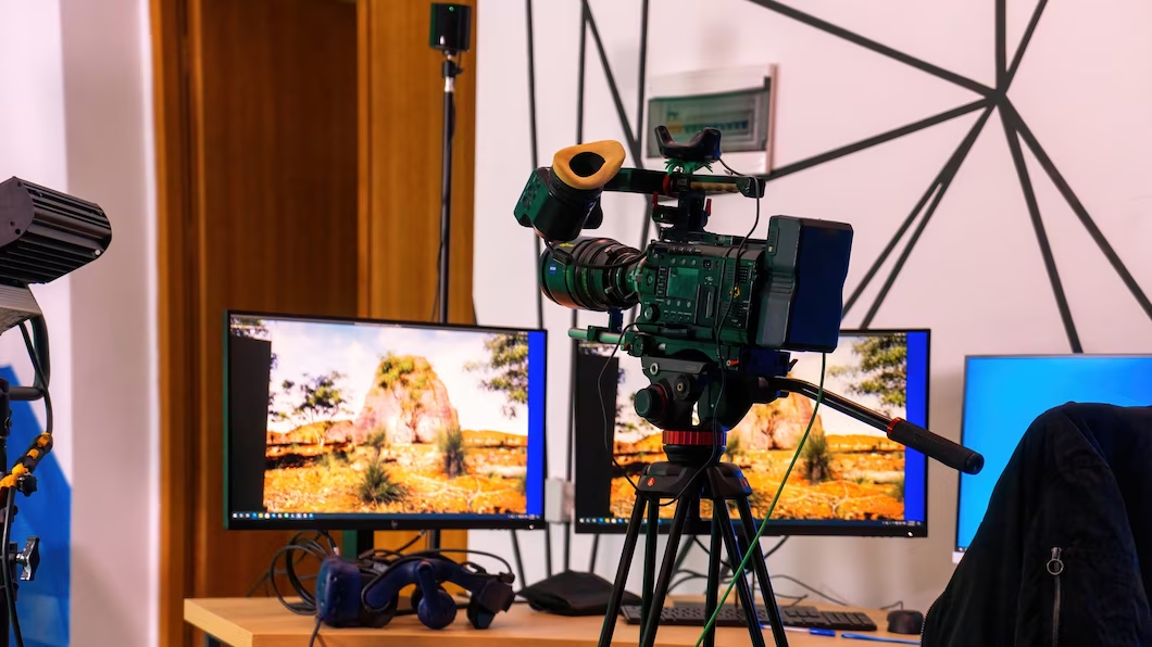 Camera mounted on a stand with monitors placed on a table