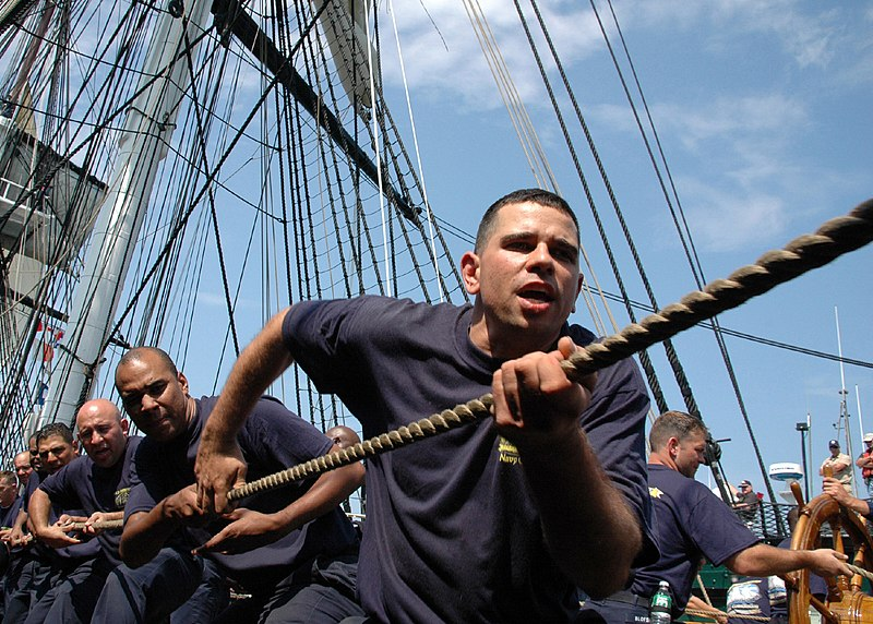 Sailors hauling away on rope.