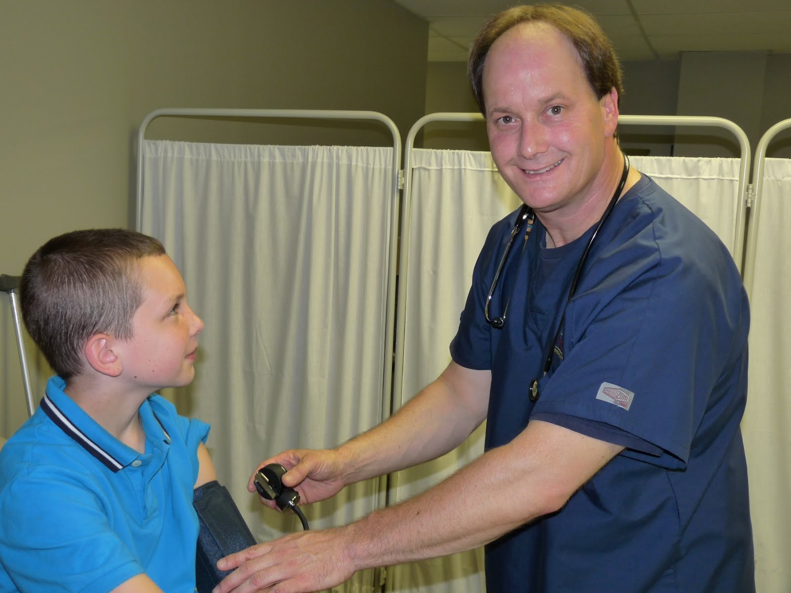 A medical assistant taking the blood pressure of a child