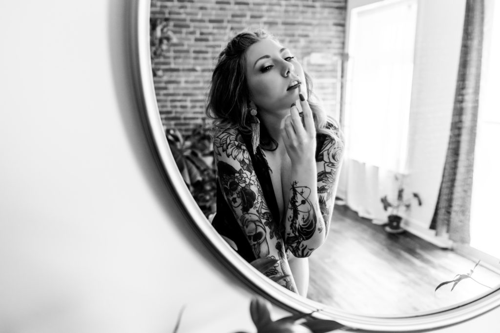 boudoir photo of woman looking at herself in the mirror