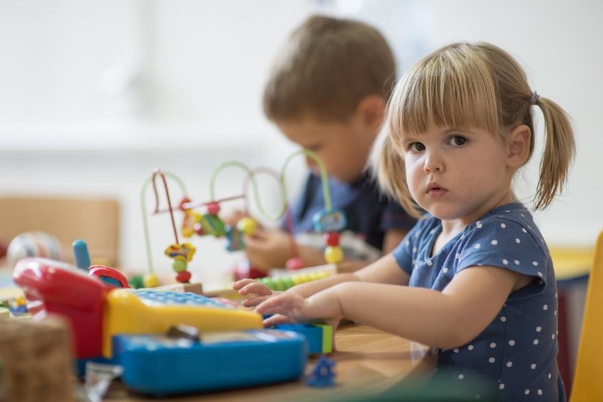 A small child sitting on a table

Description automatically generated