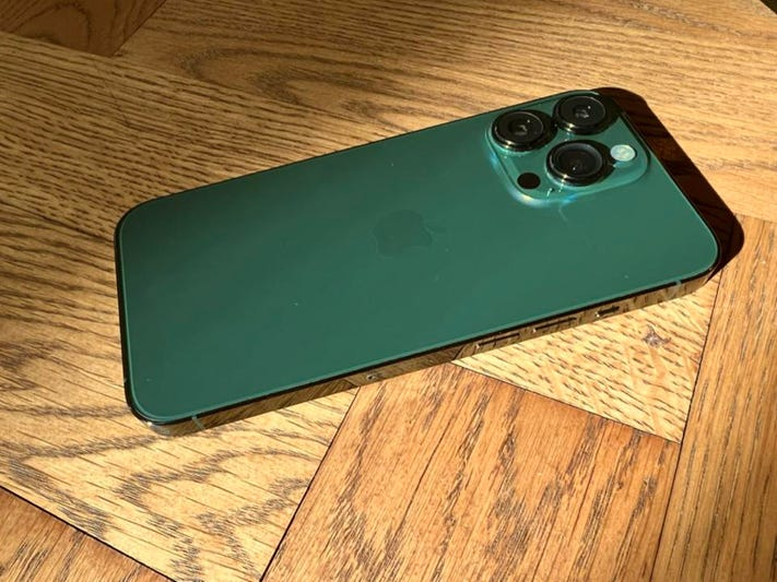 This image shows the iPhone 13 Pro green in the table under the shine of sunlight.