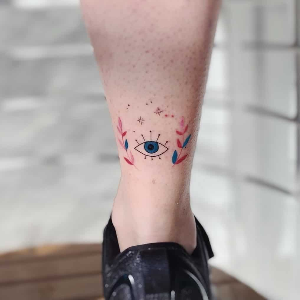 Close up view of a girl rocking the ankle  evil eye tat